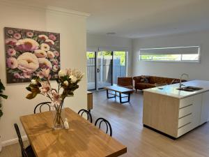 a kitchen and living room with a vase of flowers on a table at Spring Haven in Wagga Wagga
