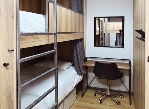 a bedroom with bunk beds with a desk and a chair at Beds Inn George in George