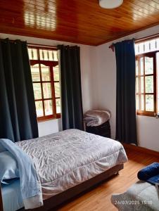 a bedroom with a bed and two windows at Casa de Campo in Chontabamba