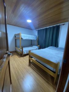 a bedroom with two beds and a bunk bed at Casa de Campo in Chontabamba