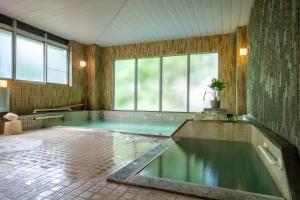 una grande piscina in una stanza con acqua al suo interno di KKRzaoHakuginso a Yamagata