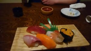 einen Teller Sushi auf einem Holztisch in der Unterkunft Sea Side Stay / Vacation STAY 1785 in Abashiri