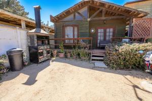 a wooden house with a stove in front of it at Algarrobo Cabaña a 2 cuadras Playa El Canelo+Wifi in Algarrobo