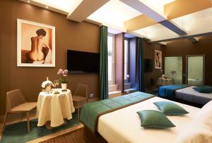 1 dormitorio con 2 camas, mesa y TV en Harry's Bar Trevi Hotel & Restaurant, en Roma