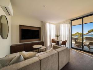 a living room with a large couch and a television at Mercure Kangaroo Island Lodge in American River