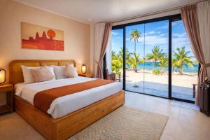 a bedroom with a bed and a view of the beach at Le Baoli Koh Rong in Phumĭ Kaôh Rŏng