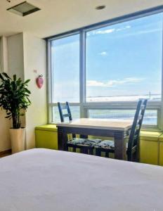 ein Raum mit Tisch und Stühlen und einem großen Fenster in der Unterkunft Cozy - Experience Home like Comfort Studio in Incheon