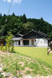 a house with a grassy yard in front of it at ひのまきbase-暖- in Uda