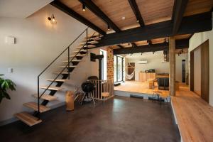 a room with a staircase and a living room at ひのまきbase-暖- in Uda
