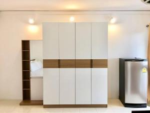 a white cabinet in a room with a refrigerator at Grandview Ladprao Hotel in Bangkok