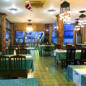 un ristorante con tavoli e sedie verdi in una stanza di Sirin Hotel Hua Hin a Hua Hin