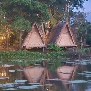 Twee rieten hutten midden in een wateroppervlak. bij Fandee Island, Lake & Treehouses - Tad Lo, Boloven Loop Pakse in Ban Kiangtat