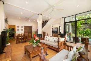 a living room with a couch and a table at Red Lotus Seminyak Villa in Seminyak