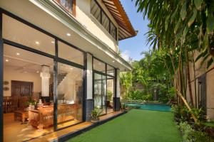 an external view of a house with a green lawn at Red Lotus Seminyak Villa in Seminyak