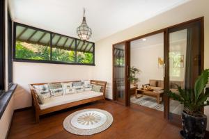 a living room with a couch and a table at Red Lotus Seminyak Villa in Seminyak