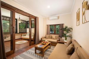 a living room with a couch and a table at Red Lotus Seminyak Villa in Seminyak +32 photos