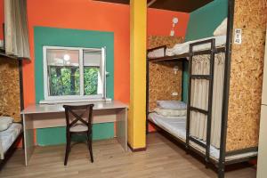 Zimmer mit einem Schreibtisch, einem Fenster und Etagenbetten in der Unterkunft day to day in Almaty