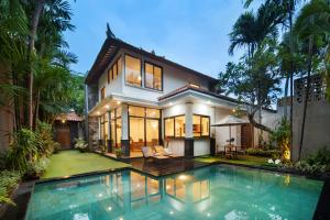 a house with a swimming pool in front of it at Red Lotus Seminyak Villa in Seminyak