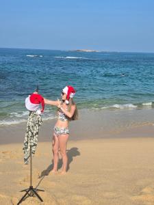 a woman in a santa hat on the beach at 1929 Sudu Colonial House in Ambalangoda