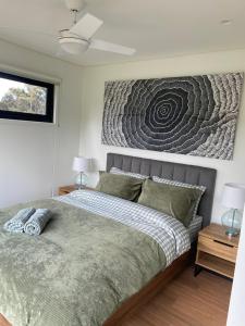 a bedroom with a bed with a picture on the wall at Grampians View Eco Retreat in Halls Gap