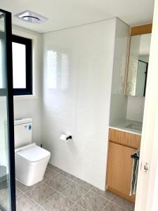 a white bathroom with a toilet and a sink at Grampians View Eco Retreat in Halls Gap