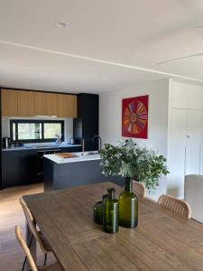 a kitchen and dining room with a wooden table at Grampians View Eco Retreat in Halls Gap +19 photos