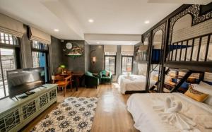 una camera con due letti a castello e un soggiorno di Lynlan Hostel & Cafe a Hat Yai