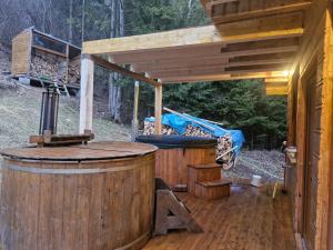 a wooden cabin with a hot tub and a pergola at Chaty Jelenye in Turzovka