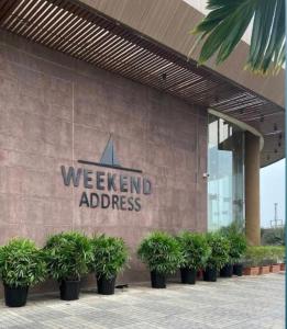 a sign on the side of a building with potted plants at Magiical weekend in Surat
