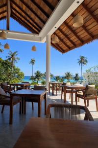 un ristorante con tavoli e sedie e vista sulla spiaggia di Le Baoli Koh Rong a Phumĭ Kaôh Rŏng