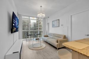 a living room with a couch and a table at Luxe 3-Bedroom Lakeview Condo, Free parking ,Walk to CN Tower, Scotiabank Arena & Rogers Centre in Toronto