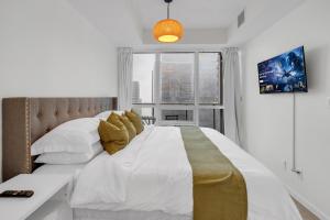 a bedroom with a large bed with a large window at Luxe 3-Bedroom Lakeview Condo, Free parking ,Walk to CN Tower, Scotiabank Arena & Rogers Centre in Toronto