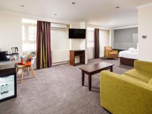 a hotel room with a bed and a couch at Mercure Chester Abbots Well Hotel in Chester