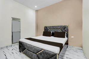 una camera da letto con un letto grande in una stanza di Hotel O The Happy Homestay a Morādābād Altre 22 foto