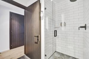 a bathroom with a shower with a wooden door at Luxury Miami Studio 27th Floor in Miami