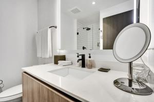 a white bathroom with a mirror and a sink at Luxury Miami Studio 27th Floor in Miami +71 photos