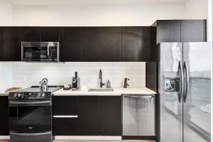 a kitchen with a stove and a sink and a refrigerator at Luxury Miami Studio 27th Floor in Miami