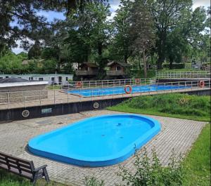 een groot blauw zwembad naast een brug bij Het Heideverblijf in Heerlen +41 foto's