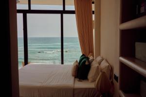 a bedroom with a bed with a view of the ocean at Soul Temple Boutique Hotel ADULTS ONLY in Ahangama