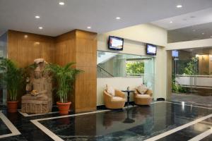 eine Lobby mit zwei Stühlen und einer Statue in der Unterkunft La Franklin Hotel in Bhubaneshwar