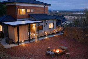 a house with a fire pit in front of it at 海の宿mare in Hakui