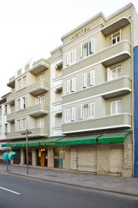 un gran edificio blanco en una calle de la ciudad en Hotel Erechim en Porto Alegre