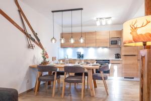 een keuken met een houten tafel en stoelen bij Tauernlodge Sonnblick Top 2 in Mühlbach am Hochkönig