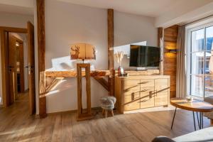 een woonkamer met een tv en een bank bij Tauernlodge Sonnblick Top 2 in Mühlbach am Hochkönig