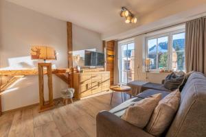 een woonkamer met een bank en een tv bij Tauernlodge Sonnblick Top 2 in Mühlbach am Hochkönig