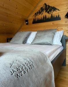 a bed in a cabin with a mountain mural on the wall at Jaworowe Wzgórze in Wysowa-Zdrój