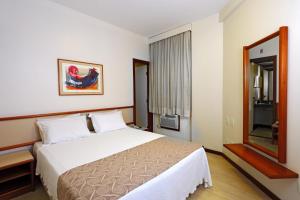 a hotel room with a bed and a window at Boulevard Express in Belo Horizonte