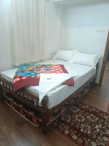 a bed sitting on top of a wooden floor at Eva homes in Vagamon