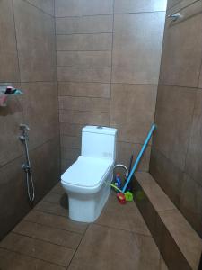 a bathroom with a toilet with a mop and a plunger at Eva homes in Vagamon