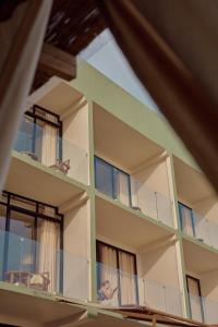 een gebouw met balkons, met een man die op het balkon zit bij Soul Temple Boutique Hotel ADULTS ONLY in Ahangama